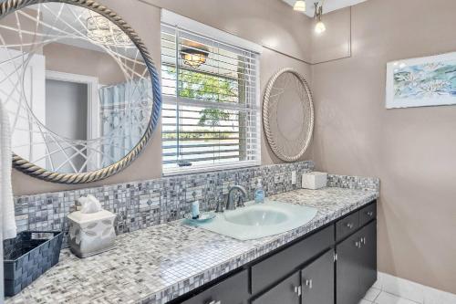 ein Badezimmer mit Waschbecken und Spiegel in der Unterkunft Lake Silver V - Lake House with Dock - Legoland Getaway! in Winter Haven