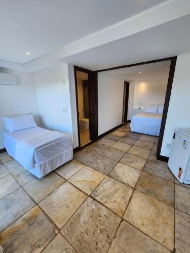 a bedroom with two beds and a tiled floor at Pousada Dreamland Buzios in Búzios