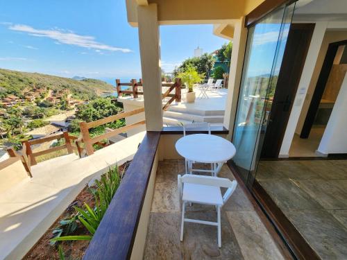 a balcony of a house with a table and chairs at Pousada Dreamland Buzios in Búzios