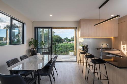 a kitchen and dining room with a table and chairs at modern immaculate residence in mount wellington in Auckland