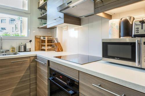 une cuisine avec un évier et un micro-ondes dans l'établissement Premium Flat In Paris Well Furnished 16th District, à Paris