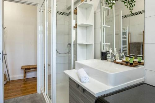 une salle de bain blanche avec un lavabo et une douche dans l'établissement Premium Flat In Paris Well Furnished 16th District, à Paris