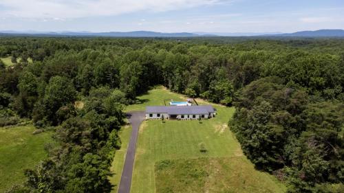 an aerial view of a large house in the middle of a forest at Oasis Near Charlottesville With Pool, Grill in Zion Crossroads