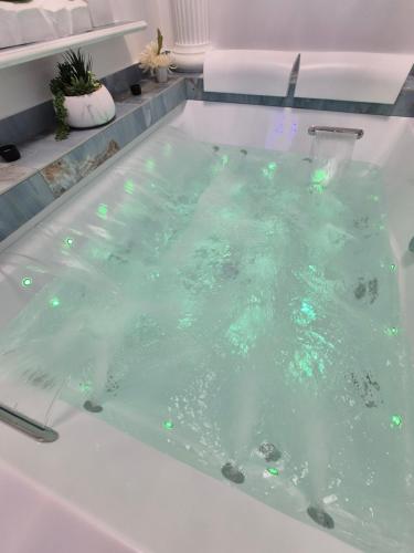 a bath tub filled with water with green lights at Albicocche house Catania in Catania