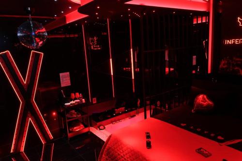 a room with a red lighted room with a table at Albicocche house Catania in Catania