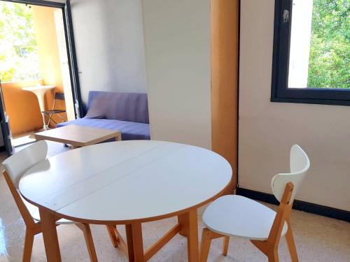 - une table et des chaises blanches dans une chambre avec un canapé dans l'établissement Studio quartier hôpitaux facultés, à Montpellier