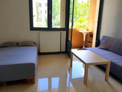 Cette chambre comprend un lit, un canapé et une table. dans l'établissement Studio quartier hôpitaux facultés, à Montpellier