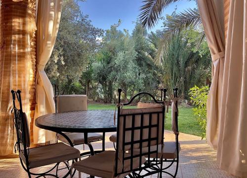 a table and chairs sitting on a patio at Palmeraie 5 Vue Piscine et Jardin in Marrakech