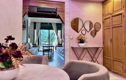 a living room with pink walls and a table and chairs at Palmeraie 5 Vue Piscine et Jardin in Marrakech