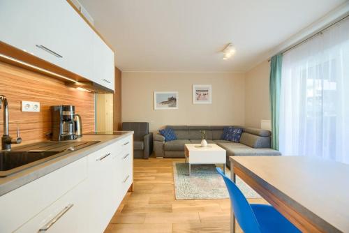 a kitchen and a living room with a couch at Studio 51 Baltic Park, 280m do Plaży, Duży balkon in Pogorzelica