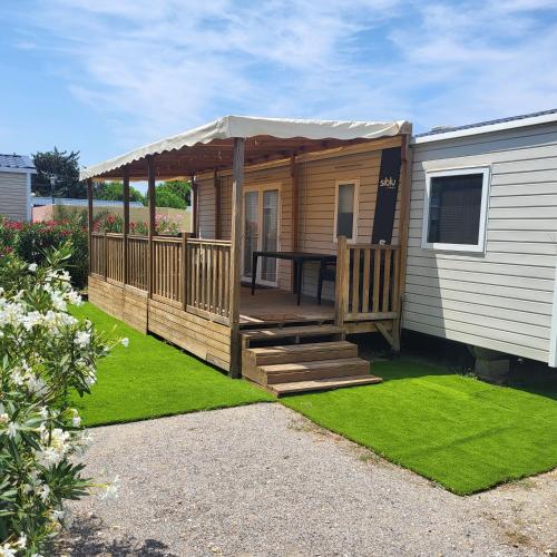 une cabine avec une terrasse avec une table à l'intérieur dans l'établissement Mar estang, Siblu, à Canet