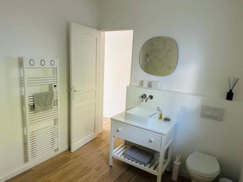 een witte badkamer met een wastafel en een toilet bij Villa des 3 Ponts, Piscine au calme in Nîmes