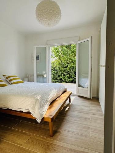 une chambre avec un lit et une grande fenêtre dans l'établissement Villa des 3 Ponts, Piscine, à Nîmes