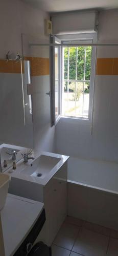 une salle de bain blanche avec un lavabo et une fenêtre dans l'établissement Maison duplex, bus à proximité pour le festival, à Avignon