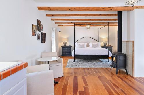 a bedroom with a bed and a wood stove at Dos Hermanas Casita 6 Downtown Courtyard Patio in Santa Fe