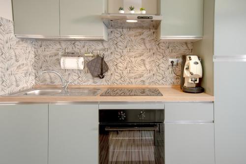 a kitchen with white cabinets and a sink at A Ridosso dei Sassi in Matera