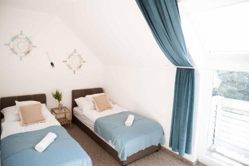 two twin beds in a room with a window at House of Kenese-Völgye in Balatonkenese