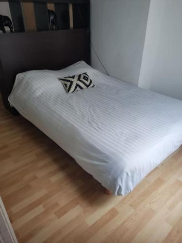 - un lit blanc avec un oreiller dans l'établissement Facile d'accès et entretenu par femme de ménage, à Paris