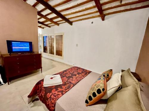 a bedroom with a bed and a tv in it at Villa Tequila-Casa Frida in Alta Gracia