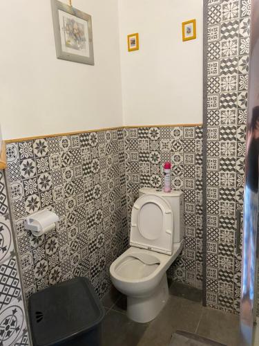 La salle de bains est pourvue de toilettes et de carrelage noir et blanc. dans l'établissement Maison de montagne rustique, à Castanet-le-Haut
