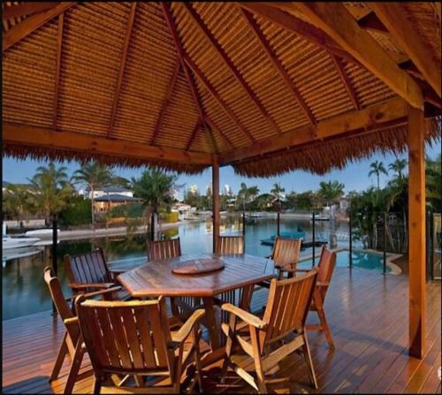 a wooden table and chairs under a wooden umbrella at Sandy Shores - Large Family Retreat in Gold Coast