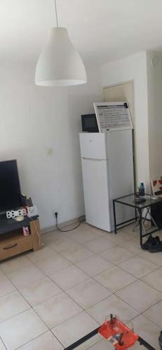 Cette chambre comprend un réfrigérateur, une table et une lampe. dans l'établissement Maison duplex, bus à proximité pour le festival, à Avignon