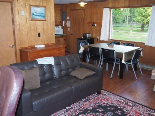 un soggiorno con un divano e un tavolo di Birch Shores Resort - The Hemlock Cottage a Empire