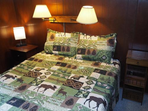 una camera da letto con un letto con una trapunta sopra di Birch Shores Resort - The Hemlock Cottage a Empire