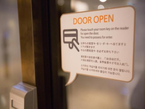 a sign that says door open on a door at Hotel PJ Myeongdong in Seoul
