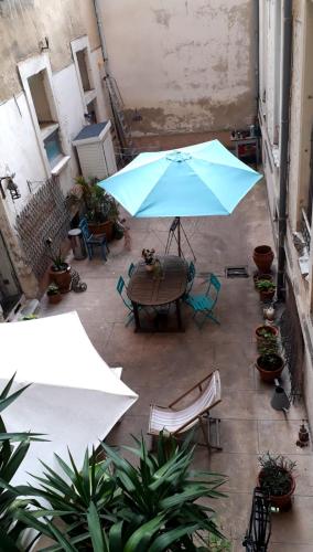 une terrasse avec une table et un parasol bleu dans l'établissement Studio place de la Comédie !, à Montpellier