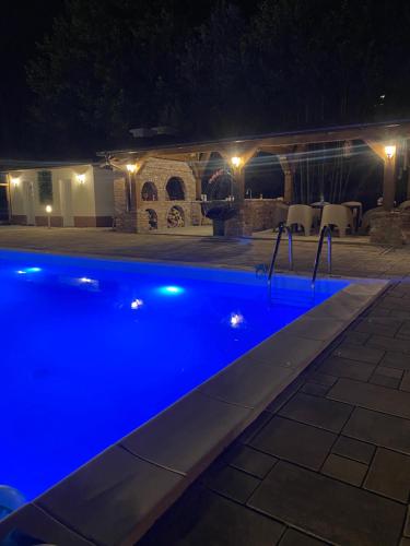 a blue swimming pool at night with a house at Sarajevo Deluxe penthouse and pool in Sarajevo