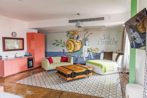 a living room with a bed and a wall with a mural at Tantalo Hotel - Kitchen - Roofbar in Panama City
