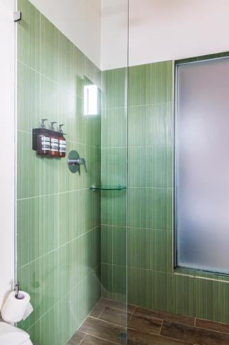 a green tiled bathroom with a glass shower at Tantalo Hotel - Kitchen - Roofbar in Panama City