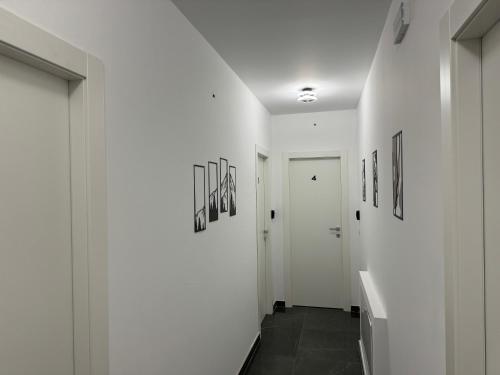 a hallway with white walls and pictures on the walls at Reale Guest House in Mascalucia