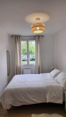 une chambre avec un grand lit blanc et une fenêtre dans l'établissement paris nest, à Stains