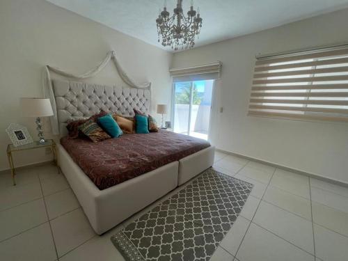 a bedroom with a large bed with blue pillows at La Villa de Sophie in Acapulco