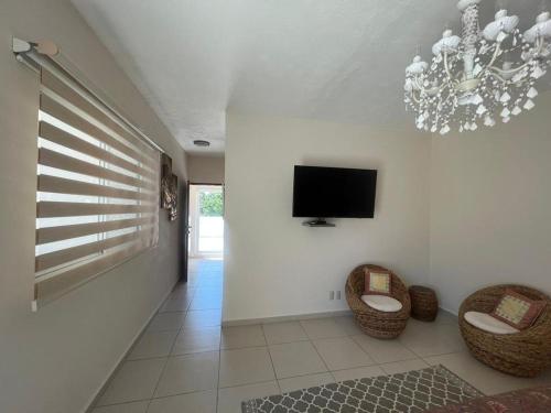 a living room with two chairs and a flat screen tv at La Villa de Sophie in Acapulco