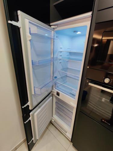 an empty refrigerator with its door open in a kitchen at Diamond Residence Qawra - Side Sea View in St. Paul's Bay