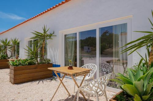 a patio with a table and chairs in front of a house at Valle D`Água - Casas de campo in Vale de Água