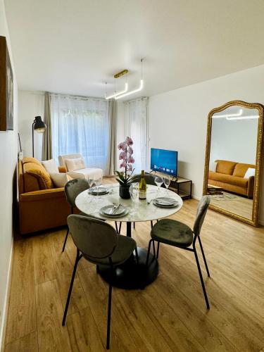 un salon avec une table, des chaises et un canapé dans l'établissement Evasion Grand Paris, à Saint-Ouen