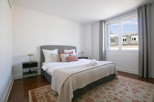 une chambre blanche avec un grand lit avec une fenêtre dans l'établissement Magnificient 2 Bedrooms with terrace next to champs-elysées - PC62B, à Paris