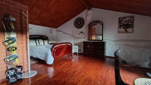 a bedroom with a bed and a dresser and a mirror at Orion Guesthouse Telhado in Fundão