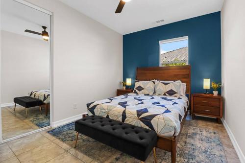 a bedroom with a bed and a blue wall at Paradise Coachella NEW Salt Water Pool & Landcape in Coachella
