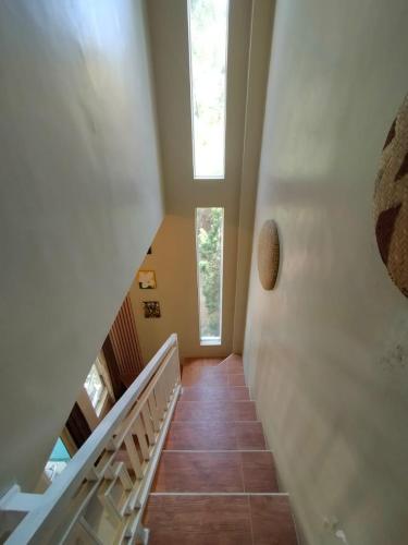 a staircase in a house with a window at Villa Gamping Favika Batu in Batu