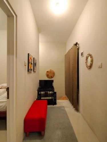 a room with a red ottoman and a bedroom at Villa Gamping Favika Batu in Batu