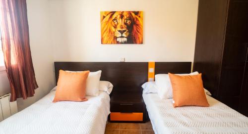 a bedroom with two beds and a painting of a tiger at H&H Suite Abrazo de Granada in Granada