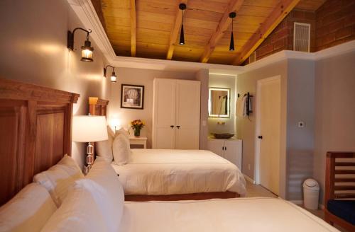 a bedroom with two beds and a wooden ceiling at Hacienda Valentino in San Cristóbal de Las Casas