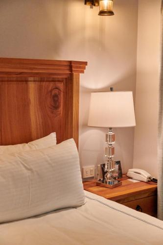 a bed with a lamp and a phone on a table at Hacienda Valentino in San Cristóbal de Las Casas