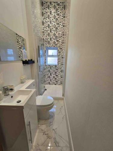 a white bathroom with a toilet and a sink at Urban Oasis 2 bed apartment in Manchester