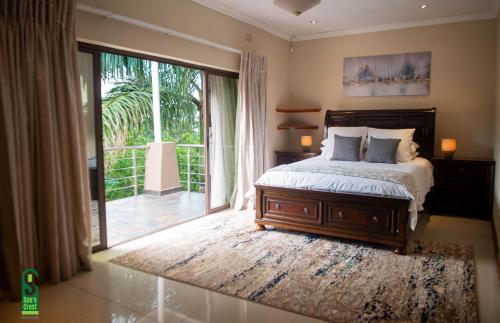 a bedroom with a bed and a large sliding glass door at Su's Crest in Blantyre
